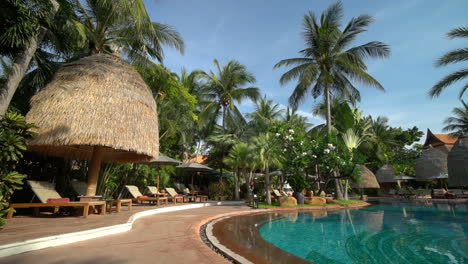 Tailandia---Alrededor-De-La-Piscina-En-Un-Complejo-Hotelero-De-Lujo-En-Tailandia,-Con-Palmeras-De-Coco-Con-Vistas-Al-Agua