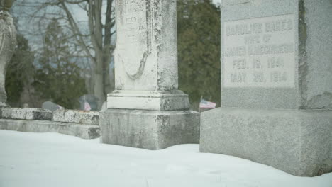 Viejas-Lápidas-Desgastadas-En-El-Cementerio-Cubierto-De-Nieve-Inclinadas-Hacia-Arriba-A-Cámara-Lenta