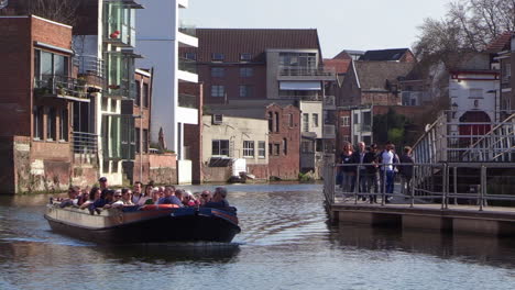 a-group-of-people-enjoying-a-sightseeing-trip-with-a-small-tourist-boat,-on-Mechelen's-inner-city-River,-The-Dijle