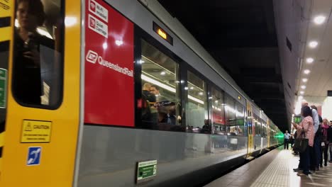 Train-full-of-commuters-pulls-away-from-a-platform,-as-another-arrives-from-the-opposite-direction-in-Brisbane-Australia