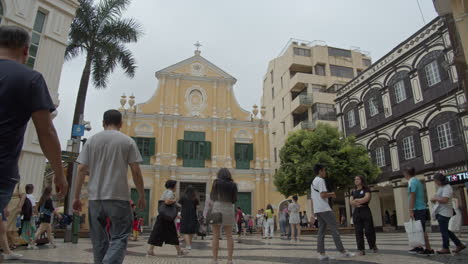 Touristen,-Die-Auf-Dem-Kleinen-Platz-In-Der-Nähe-Der-Gelb-Gefärbten-Kirche-Im-Barockstil-Spazieren-Gehen