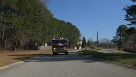 Firetruck-driving-on-a-residential-street-with-emergency-lights-flashing-to-respond-to-a-fire