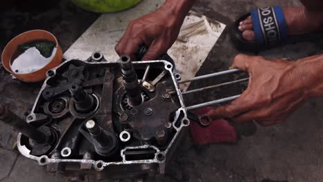 Mechaniker-Kauert-Auf-Dem-Bürgersteig,-Um-Motorteile-Für-Einen-Der-Millionen-Motorroller-In-Ho-Chi-Minh-Stadt,-Vietnam,-Zu-Reparieren