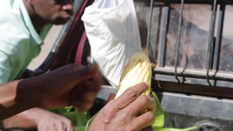 Man-prepares-corn-to-be-sold-at-the-morning-market,-in-Capelinha,-Minas-Gerais,-Brazil