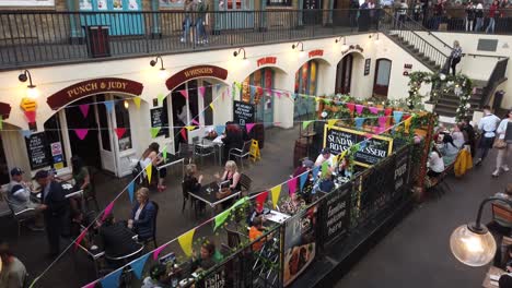 Covent-Garden-in-London,-showing-people-eating-in-restaurants-and-shopping-in-boutiques