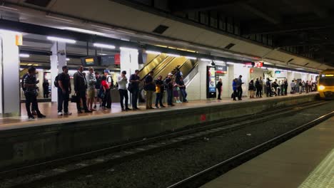 Los-Viajeros-De-La-Hora-Pico-Esperan-Un-Tren-Cuando-Llega-A-La-Plataforma,-En-La-Estación-Central-De-Brisbane,-Australia