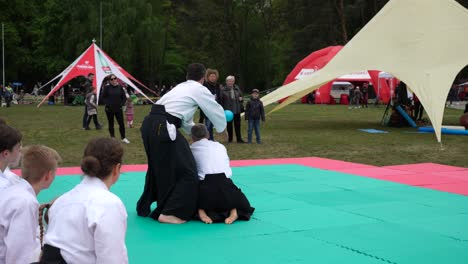 Männer-Tragen-Traditionelle-Kleidung-Und-Zeigen-Ihren-Schülern-Aikido-Bewegungen
