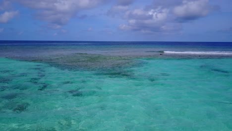 Gloomy-day-with-grey-clouds-on-sky-and-dark-blue-sea-waving-over-calm-turquoise-lagoon-in-Antigua-seascape,-copy-space