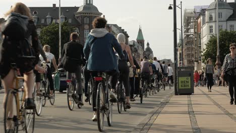 People-riding-bicycle-on-street-of-Copenhagen,-cyclist-crowd