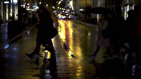 Gente-Cruzando-La-Calle-Durante-Una-Noche-Lluviosa-Y-Húmeda-En-Munich