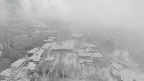 Luftaufnahmen-Eines-Verschneiten-Berges,-Eines-Traditionellen-Dorfes-In-Griechenland-3