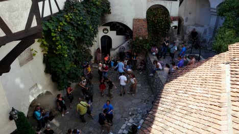 Tilt-up-shot-of-People-dancing-swing-inside-the-Bran-castle-courtyard-on-a-bright-summer-day