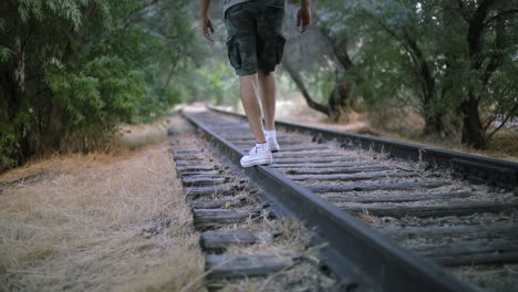 Aufnahme-Von-Jemandem,-Der-Auf-Verlassenen-Bahngleisen-Auf-Die-Kamera-Zugeht