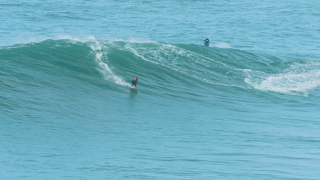 Surfer-Fängt-Welle-In-Nazare,-Portugal,-Schwenk-Zum-Folgen,-Zeitlupe-Mit-60-Bildern-Pro-Sekunde