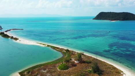 Costa-De-Isla-Tropical-Con-Una-Estrecha-Franja-De-Playa-De-Arena-Que-Entra-En-Una-Tranquila-Laguna-Turquesa,-Tailandia