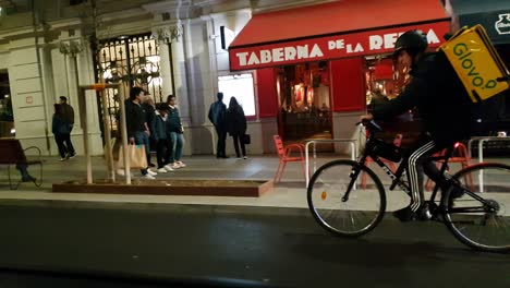 Toma-Nocturna-Desde-La-Conducción-De-Un-Automóvil-Mirando-El-Tráfico-Y-La-Acera-En-La-Gran-Vía-En-La-Capital-De-España,-Madrid