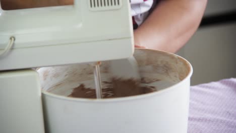 Female-hand-controling-food-mixer-preparing-chocolate-cake-dough