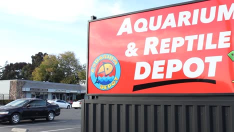Aquarium-and-Reptile-Depot-Street-Sign-Pan-to-Wide-Shot-of-Building