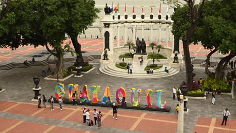 Timelapse-of-people-visiting-the-Rotonda-Monument-and-the-letters-Guayaquil-in-Malecon-Simon-Bolivar,-Guayaquil