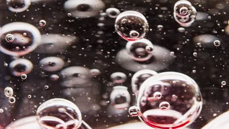 Makroaufnahme-Von-Roten-Blasen,-Die-In-Wasser-Gemischt-Werden