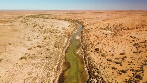 Hochfliegende-Drohnenaufnahmen-Eines-Von-Quellen-Gespeisten-Flusses,-Der-Sich-Durch-Die-Trockene-Australische-Wüstenregion-Schlängelt