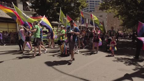 Seattle-Sounders-employees-and-band-members-participating-in-the-Seattle-LGBTQ-parade,-marching-band,-waving-rainbow-flags