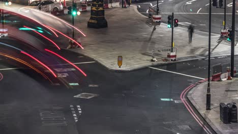 Vista-Nocturna-Desde-Lo-Alto-Del-Tráfico-Londinense-En-Los-Semáforos:-Autobuses-Rojos,-Taxis,-Automóviles-Y-Peatones