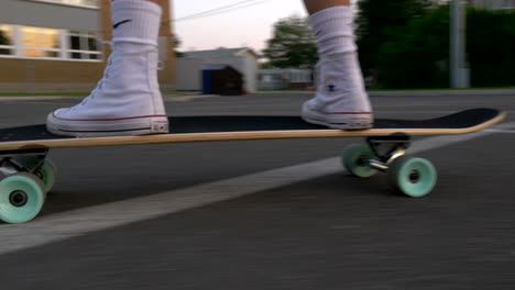 female-feet-on-skateboard,-close-up-low-angle-tracking-shot