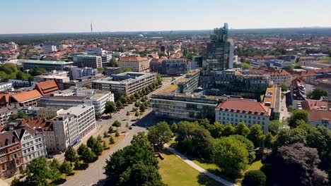 An-aerial-view-of-traffic-passing-by-with-lots-of-urban-and-old-buildings-surrounding-in-Hanover,-Germany