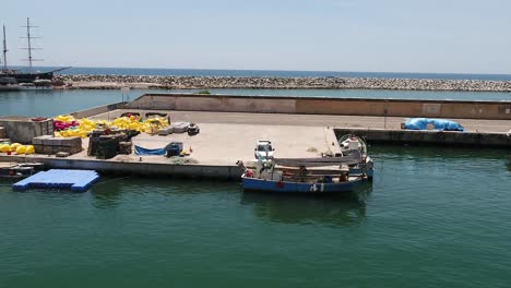 Vista-Aérea-De-Una-Tripulación-Que-Trabaja-En-Un-Barco-En-El-Puerto-De-Arenys-De-Mar-Cerca-De-Barcelona,-España