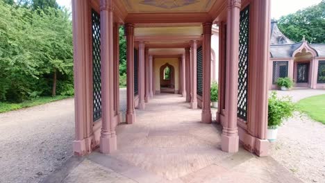 Toma-En-Cámara-Lenta-Caminando-Por-Las-Columnatas-Del-Castillo-De-Schwetzingen,-Alemania