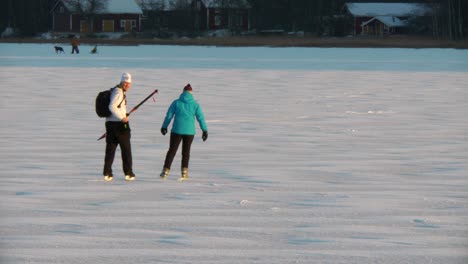 Pareja-Disfrutando-Del-Patinaje-Sobre-Hielo-Natural,-Actividades-De-Invierno-En-Un-Lago-En-Ostrobotnia,-Finlandia