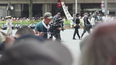 Camarógrafo-Filmando-El-Evento-Con-Una-Cámara-De-Cine-Durante-Las-Procesiones-Yamaboko-Junko-Del-Desfile-De-Carrozas-Del-Festival-Gion-Matsuri-En-Kyoto,-Japón