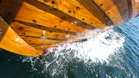 Sea-Water-Splashing-As-A-Wooden-Boat-Sails-In-Arendal,-Norway---close-up-slowmo