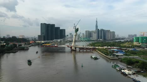 Luftaufnahmen-In-Richtung-Thu-Thiem.-Zwei-Im-Bau-Befindliche-Brücken-Mit-Wichtigen-Gebäuden-Der-Skyline-Von-Saigon,-Darunter-Der-Vinhomes-Golden-River-Und-Das-Wahrzeichen