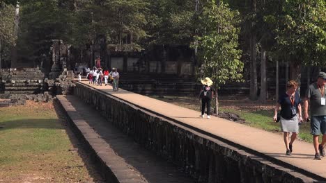Langes-Herauszoomen-Von-Touristen,-Die-Einen-Tempel-Auf-Dem-Gehweg-In-Angkor-Wat-Verlassen