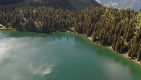 Aerial-of-beautiful-lake-near-stunning-mountainside-in-Switzerland