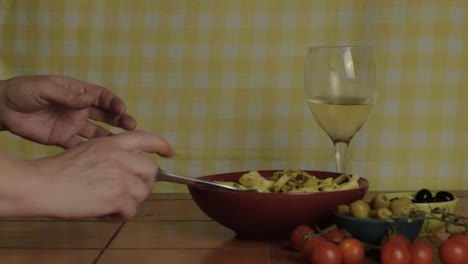 Woman-eating-lunch-of-pasta-with-white-wine-medium-shot