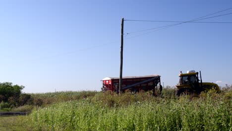 Blick-Auf-Einen-Traktor,-Der-Einen-Ernteanhänger-Durch-Eine-Landstraße-In-Santa-Fe,-Argentinien,-Trägt