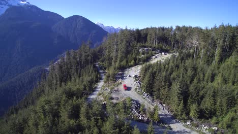 A-wide-Aerial-orbiting-view-of-a-Red-Jeep-Wrangler-parked-on-an-off-road-trail-in-Mission-BC