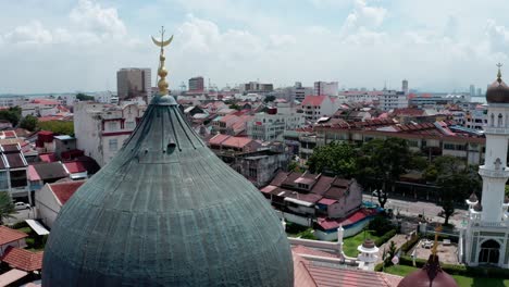Kapitan-Keling-Mosque-main-dome-and-minaret-tower-in-George-Town-area,-Aerial-drone-orbit-around-shot