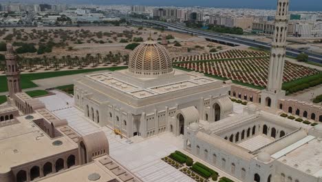 Luftdrohnenaufnahme-Der-Beeindruckenden-Großen-Sultan-Qabus-Moschee,-Die-Von-Links-Nach-Rechts-Schwenkt-Und-Dabei-Die-Stadt-Maskat-In-Maskat-Im-Oman-überblickt