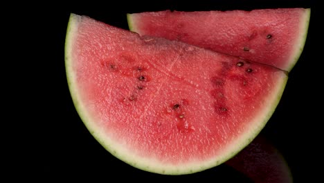 Pan-shot-showing-slices-of-fresh-delicious-watermelon-with-black-background