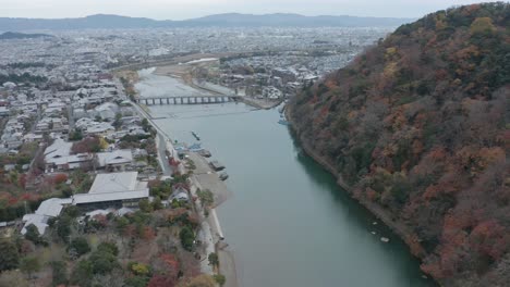 Tilt-up-revealing-Kyoto,-Ancient-capital-of-Japan-at-Arashiyama-and-Togetsukyo-Bridge
