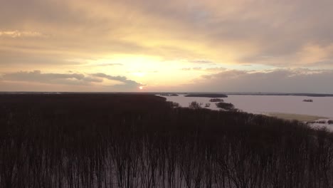 Drohne-Fliegt-über-Wald-Und-Nähert-Sich-Der-Küstenregion-Mit-Eisbedecktem-Wasser