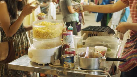 Lady-Buying-Some-Corn-at-a-Snack-Stand-at-Night