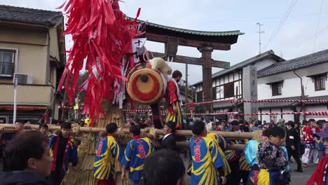 Japanese-men-carrying-Year-of-the-Rat-Sagicho-Festival-in-front-of-Torii-gate