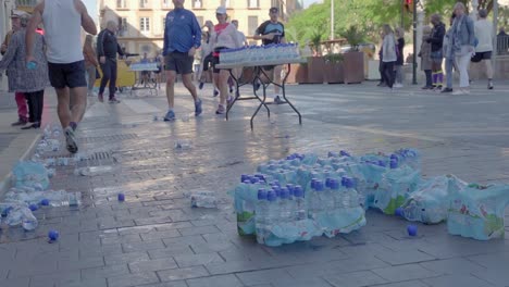 Marathon-contestants-throw-empty-plastic-water-bottles-to-side,-Malaga