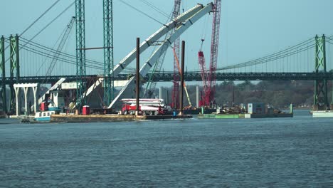 Tugboat-maneuvering-a-barge-with-concrete-pumper-truck-on-the-Mississippi-River-at-Moline,-Illinois