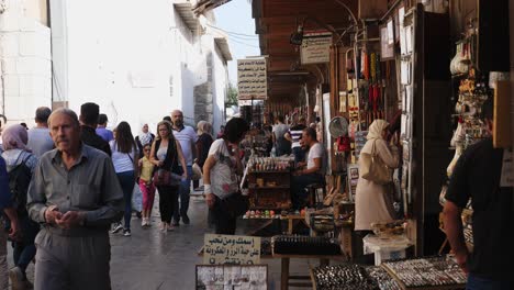 Still-shot,-several-tourists-walking-along-the-souvenir-shops-in-Damascus,-Syria